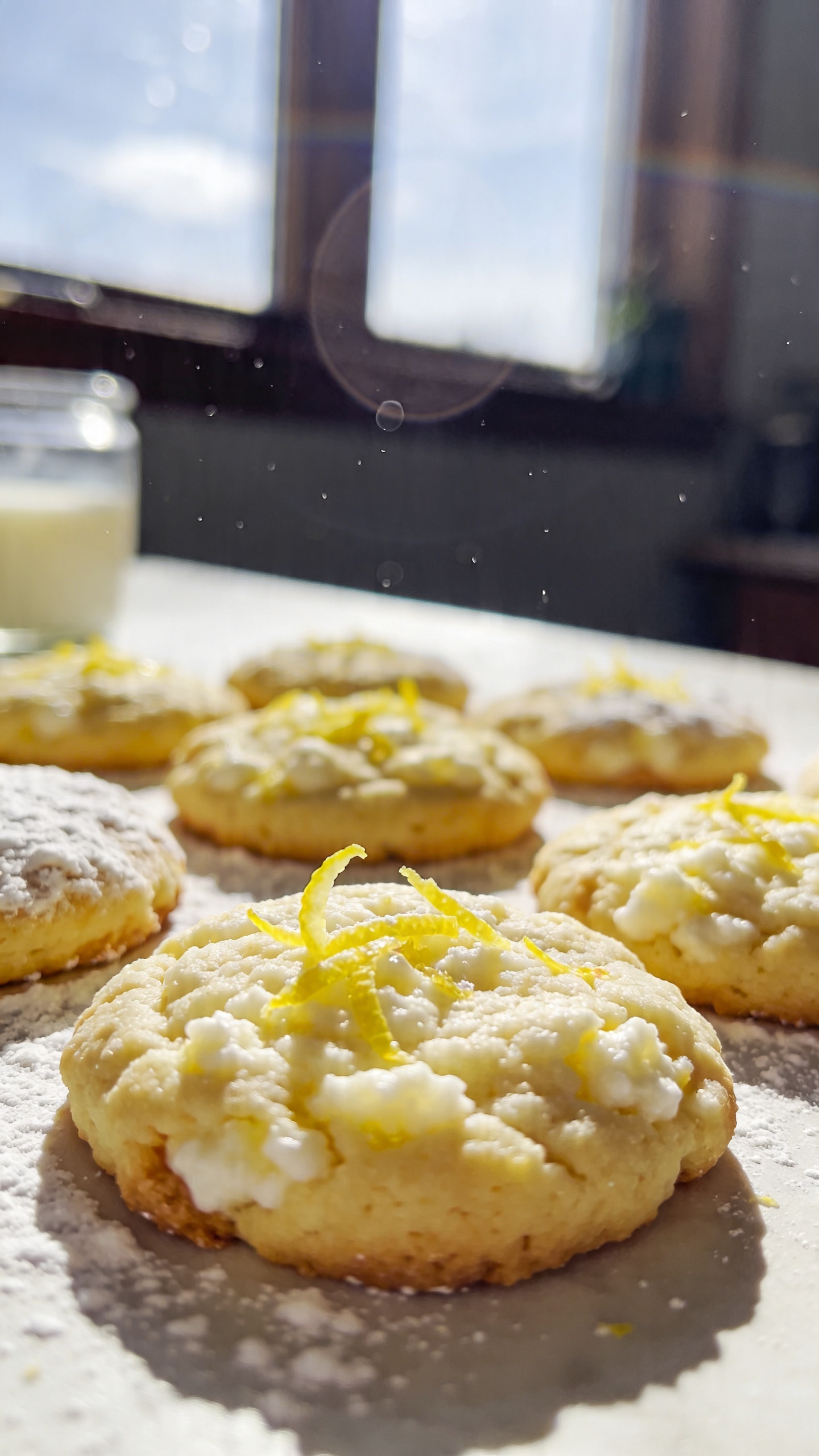 A real, authentic photo of lemon zest lift cookies with cottage cheese as the main subject, captured as if shot casually with an iPhone. Natural window light streaming in, casual kitchen/table setting, slight imperfect composition to feel spontaneous. The cookies should look bright, lemony, with visible lemon zest, a light texture and a crisp edge, as if freshly baked and ready for a quick energy boost. Include a touch of vanilla in the background, a light dusting of powdered sugar if you’re entertaining, and a sense of freshness for spring. Include natural phone-camera imperfections: slight overexposed highlights from sun, gentle lens flare, minor motion blur from a quick snap, grain varying with light, and a slightly tilted horizon. No text on the image. Shot quickly, no staging, fingerprint on lens, compressed 1080p quality, screenshot-like feel, with a hint of post-processing that keeps it natural (scaled down and up again, slight smart blur with sharpening, recolored with a flat paint bucket to avoid an over-polished look). The main subject to be centered around the cookies themselves, showcasing fresh lemon zest and cottage cheese-inspired texture.
